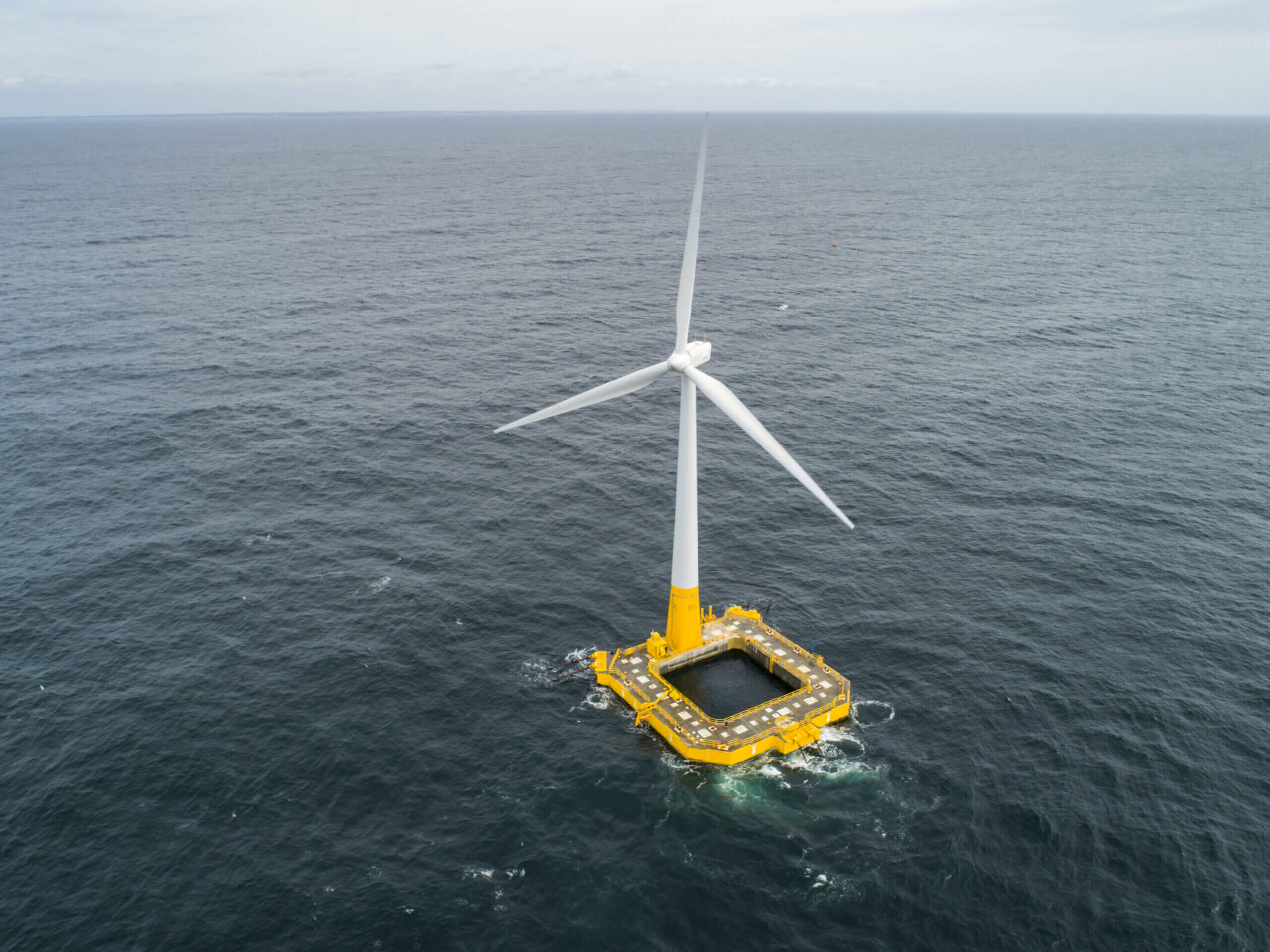 The Floatgen turbine at sea, mounted on its yellow square Damping Pool floating foundation